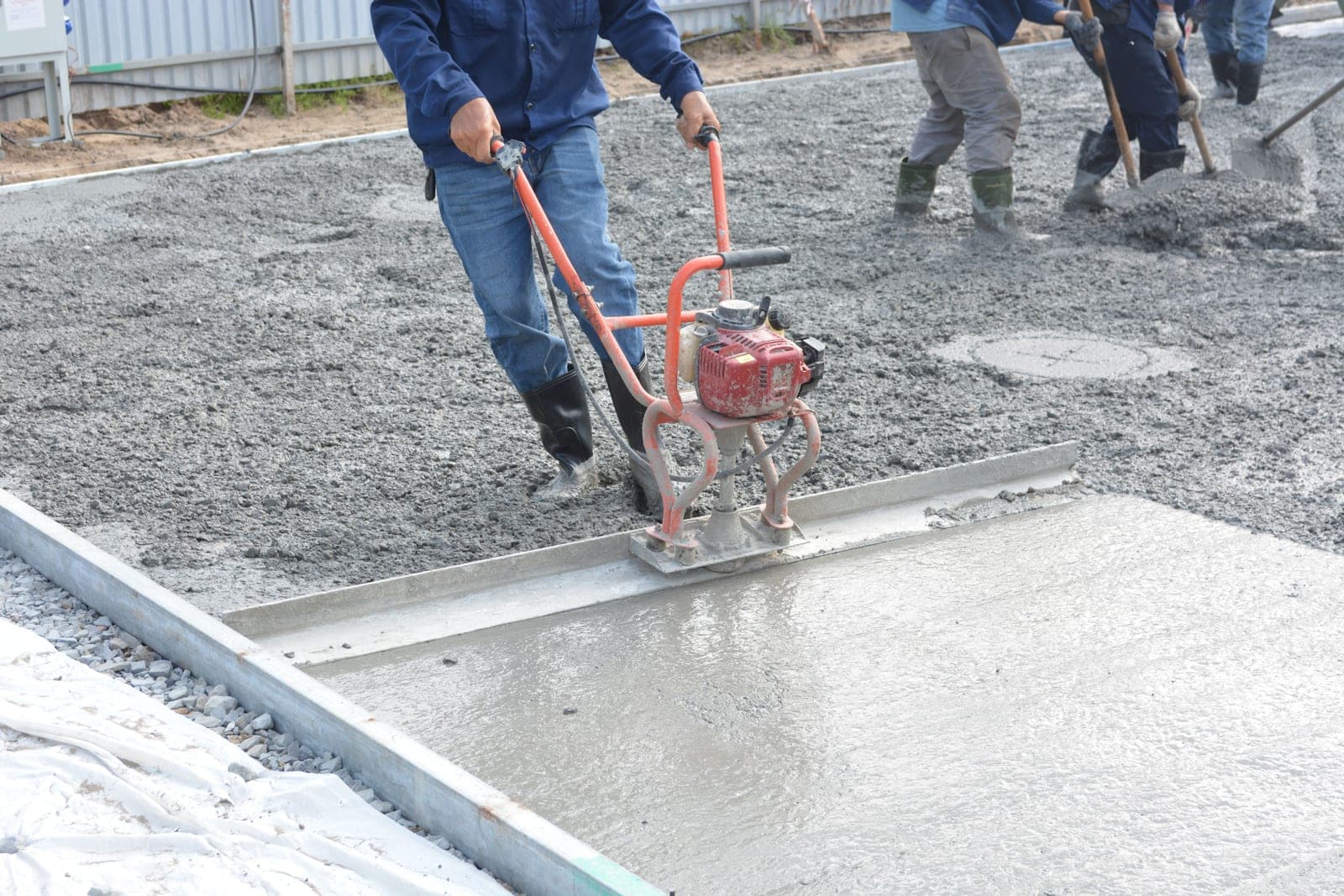 A concrete slab being screeded flat during the pour.